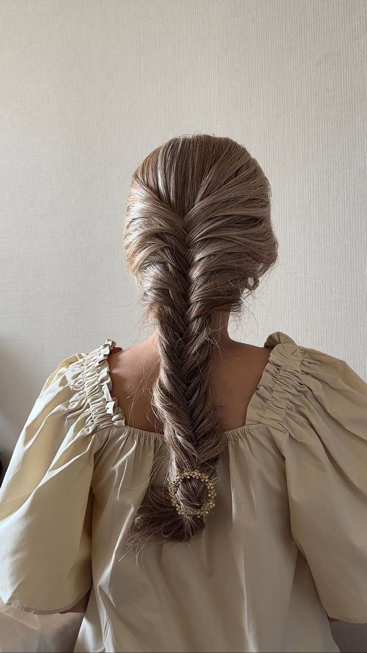 12 Braids Hairstyles: 29 Ideas, From Box Braids to Milkmaid 12 Light brown fishtail braid with a pearl accessory on a person's back