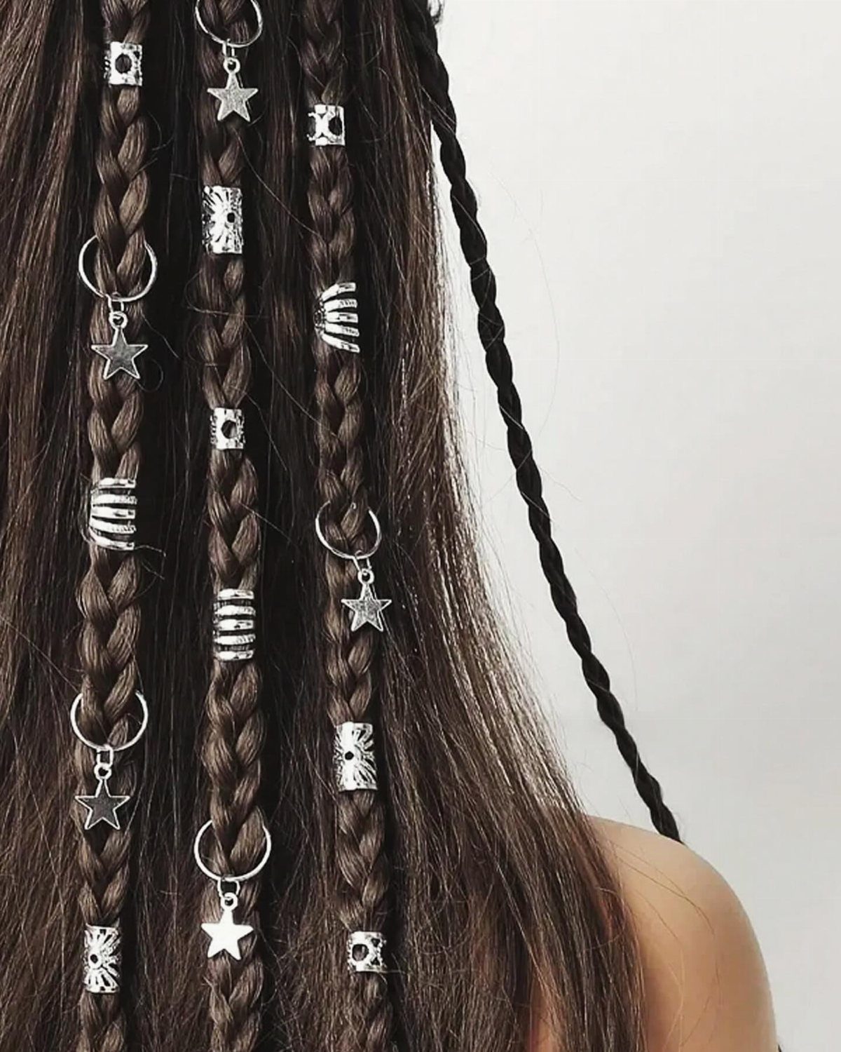12 Braids Hairstyles: 29 Ideas, From Box Braids to Milkmaid 26 Brown braided hair decorated with silver star charms and metallic hair beads.