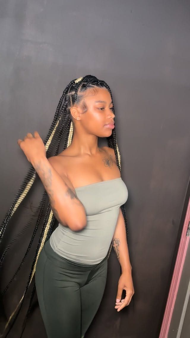 12 Braids Hairstyles: 29 Ideas, From Box Braids to Milkmaid 7 Woman with long black and blonde knotless braids wearing a green outfit.