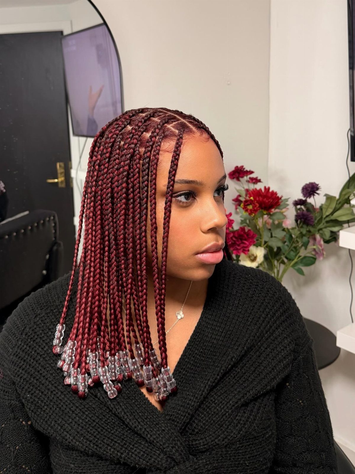 12 Braids Hairstyles: 29 Ideas, From Box Braids to Milkmaid 21 Woman with burgundy box braids featuring clear raindrop-shaped beads at the ends.