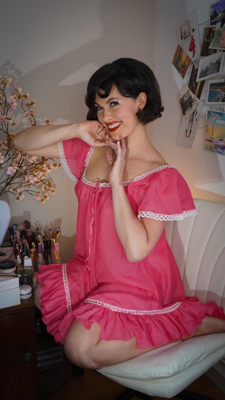 1960s Hairstyles: 7 Ideas from Beehives to Bubble Cuts 4 Woman with a rounded bubble cut hairstyle wearing a pink ruffled dress.