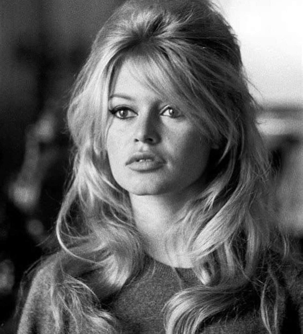 1960s Hairstyles: 7 Ideas from Beehives to Bubble Cuts 8 Woman with voluminous 1960s bouffant blonde hair and long waves in black and white.