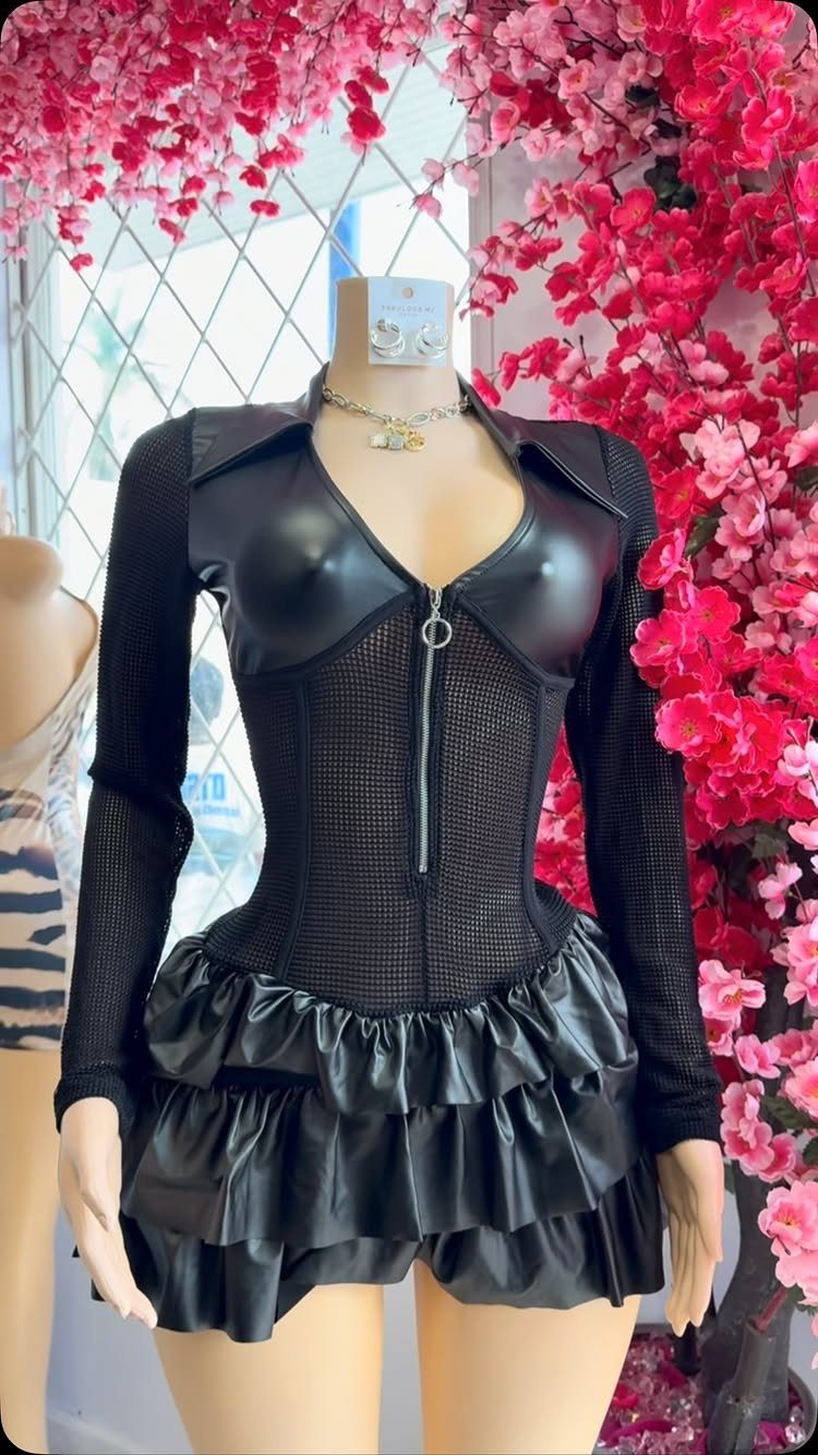 Black leather corset top and ruffled mini skirt on a mannequin with pink flowers.