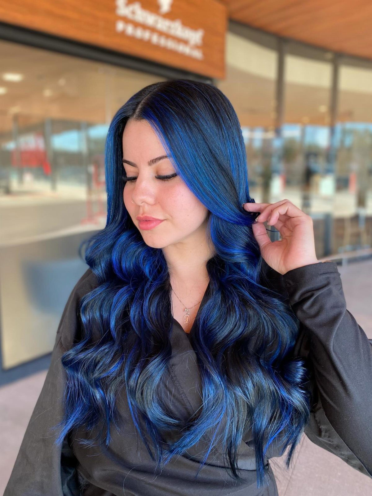 8 Blue Highlights for Brown Hair Ideas and Styles 7 Woman with long dark wavy hair and vibrant electric blue highlights