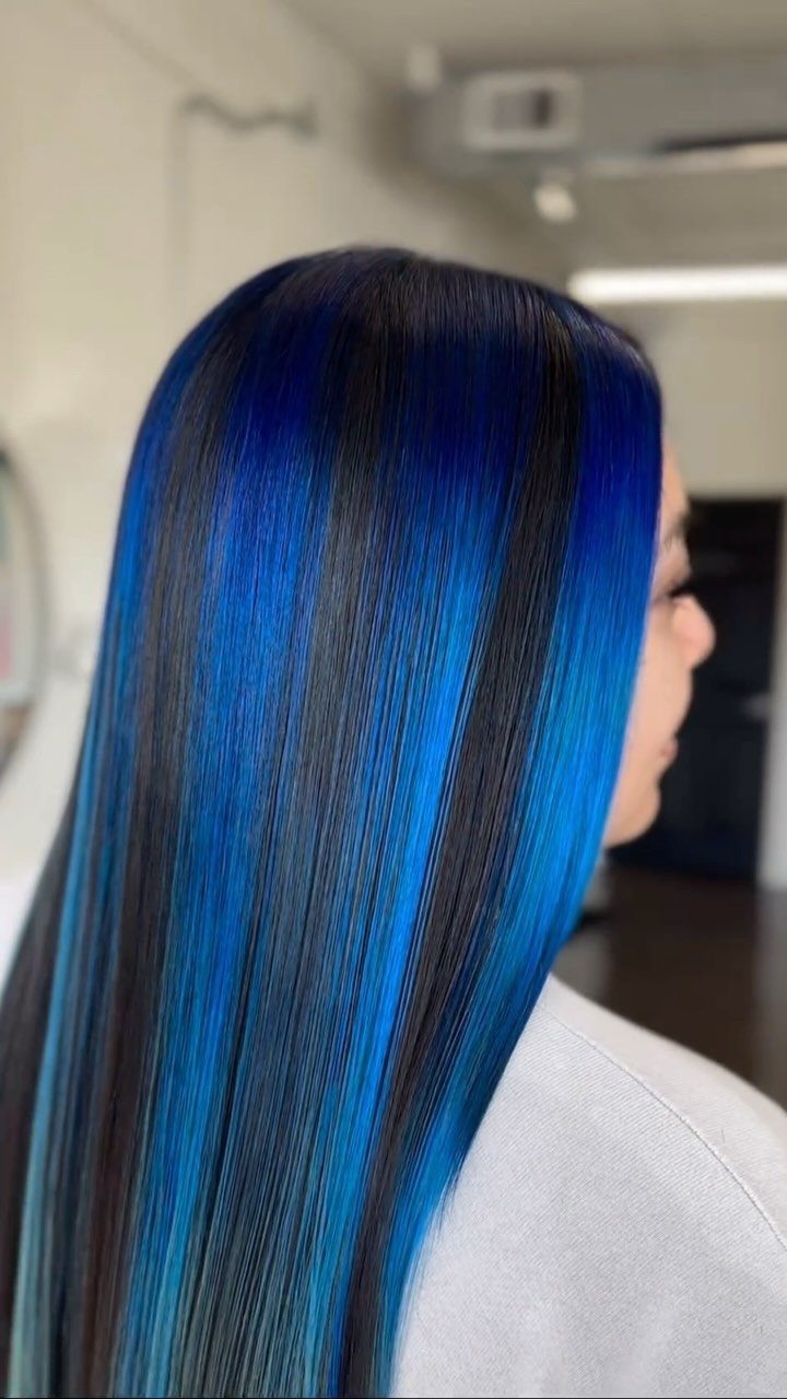 8 Blue Highlights for Brown Hair Ideas and Styles 4 Long straight dark brown hair with bold, vibrant royal blue vertical highlights.