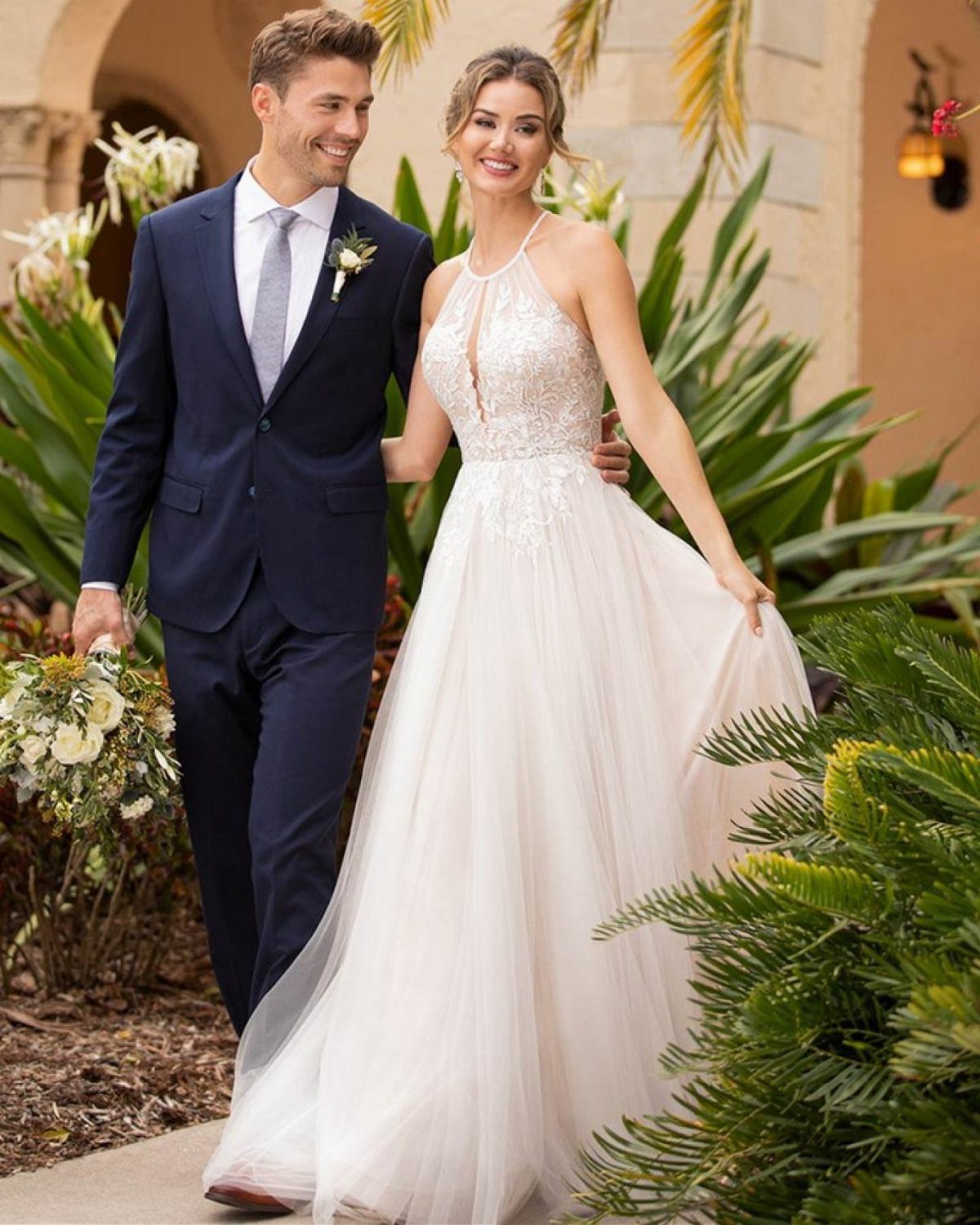 25 Blush Wedding Dress Ideas in Lace, Tulle, Silk and Sequins 16 Couple walking outdoors, woman wearing a blush halter-neck wedding gown with tulle skirt