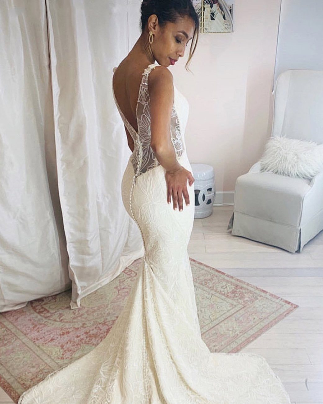 25 Blush Wedding Dress Ideas in Lace, Tulle, Silk and Sequins 9 Woman in a white lace mermaid wedding dress with a sheer back and flared skirt.