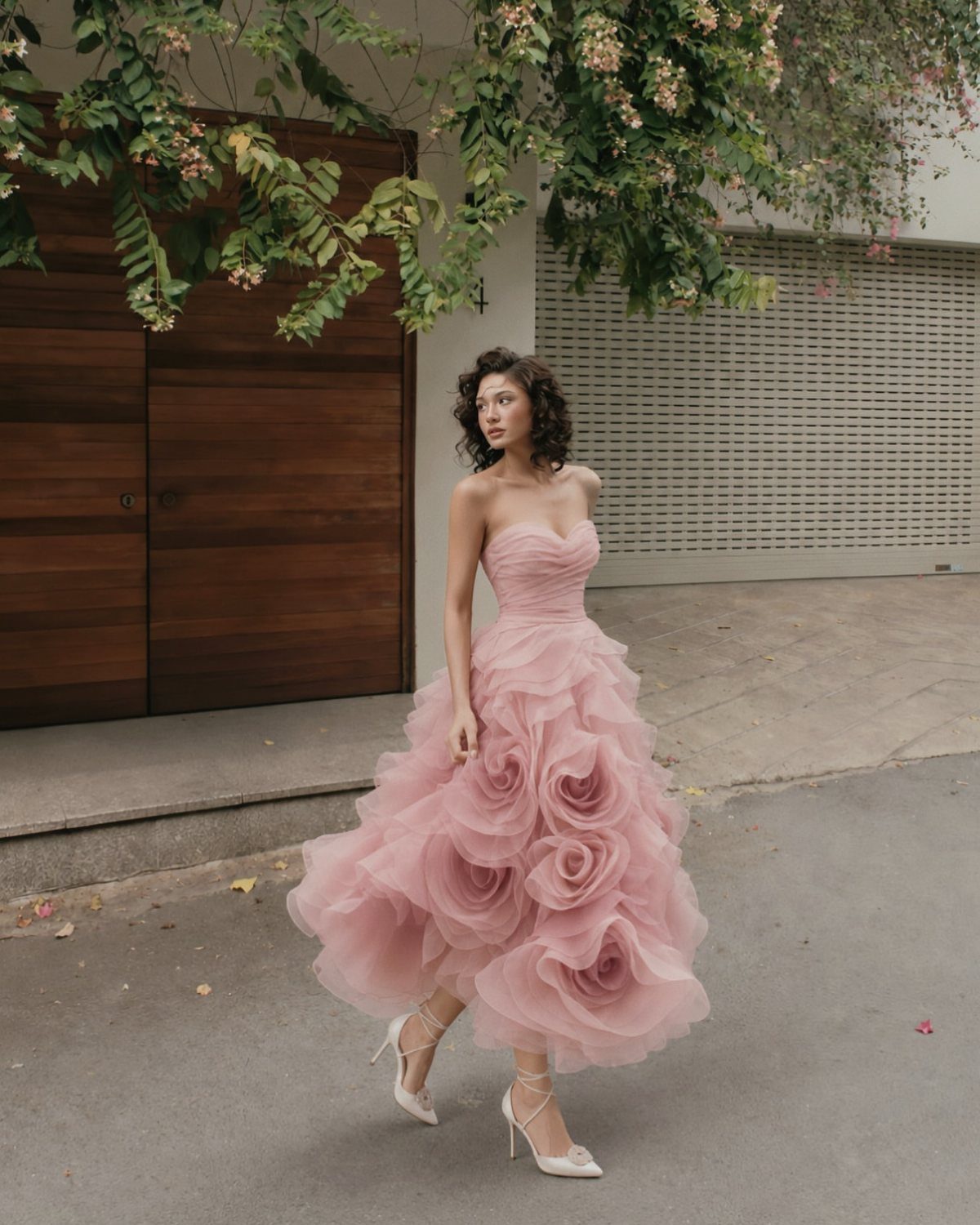 25 Blush Wedding Dress Ideas in Lace, Tulle, Silk and Sequins 4 Woman in a strapless blush pink tulle gown with large rosette skirt details.