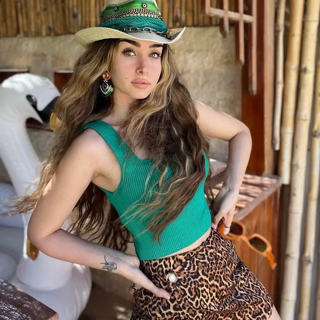 Casual Outfits for Las Vegas: 35 Ideas for Day and Night 35 Woman wearing a sun hat, green crop top, and leopard print skirt outdoors.