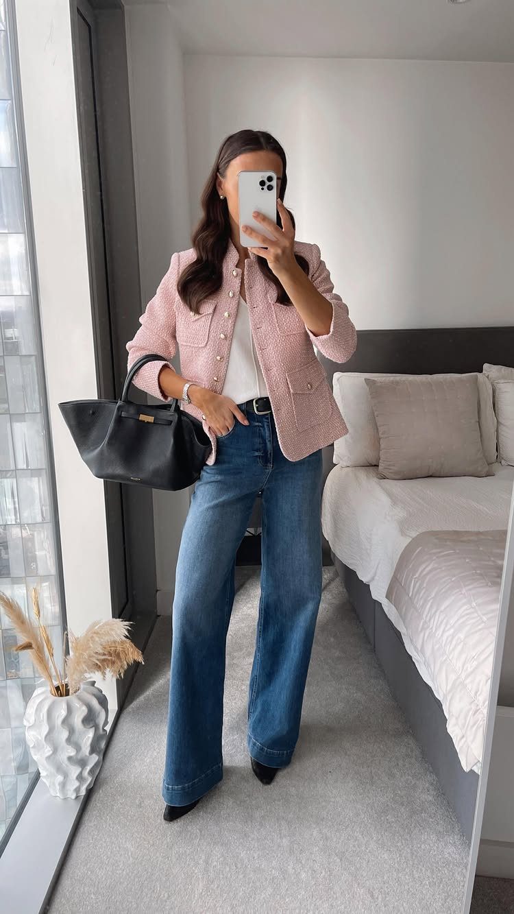 Casual Outfits for Las Vegas: 35 Ideas for Day and Night 18 Woman in a pink blazer and wide-leg blue jeans posing for a mirror selfie.