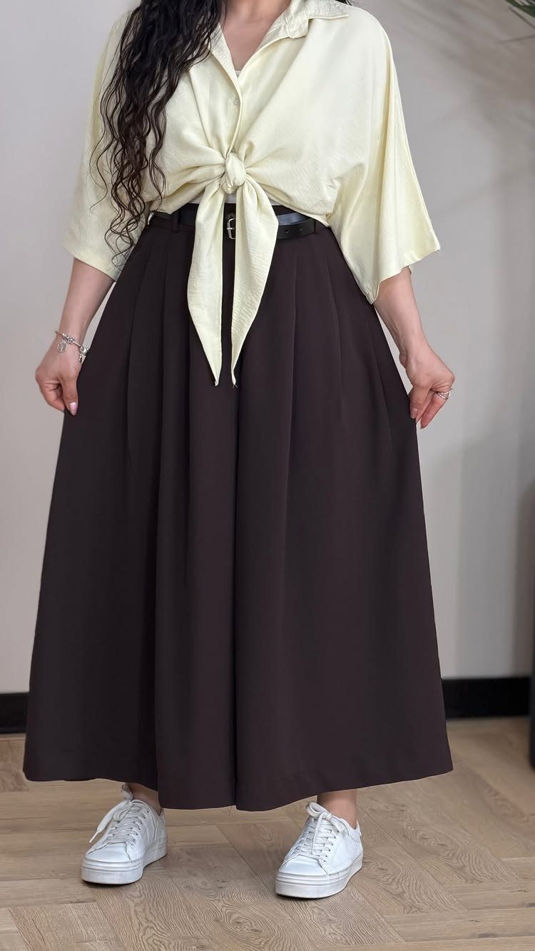 Casual Outfits for Las Vegas: 35 Ideas for Day and Night 29 Person wearing a cream tied blouse and wide-leg dark brown dressy pants.