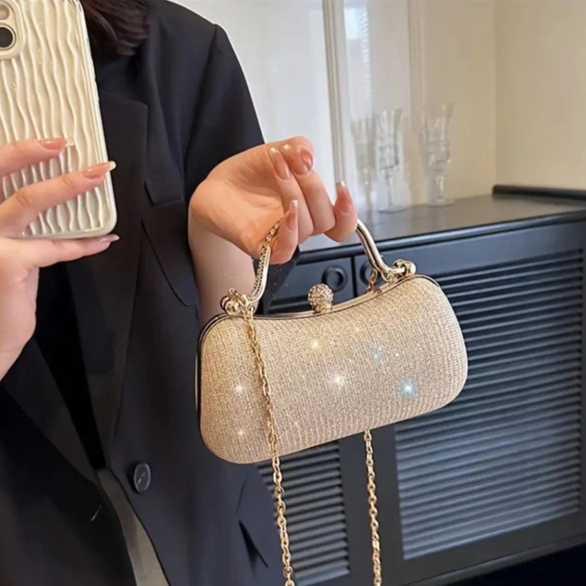 Casual Outfits for Las Vegas: 35 Ideas for Day and Night 36 Gold sparkly clutch bag with a chain strap held by a person in black.