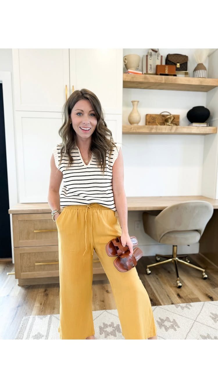 Casual Outfits for Las Vegas: 35 Ideas for Day and Night 20 Woman wearing a striped top and wide-leg yellow pants holding brown sandals.
