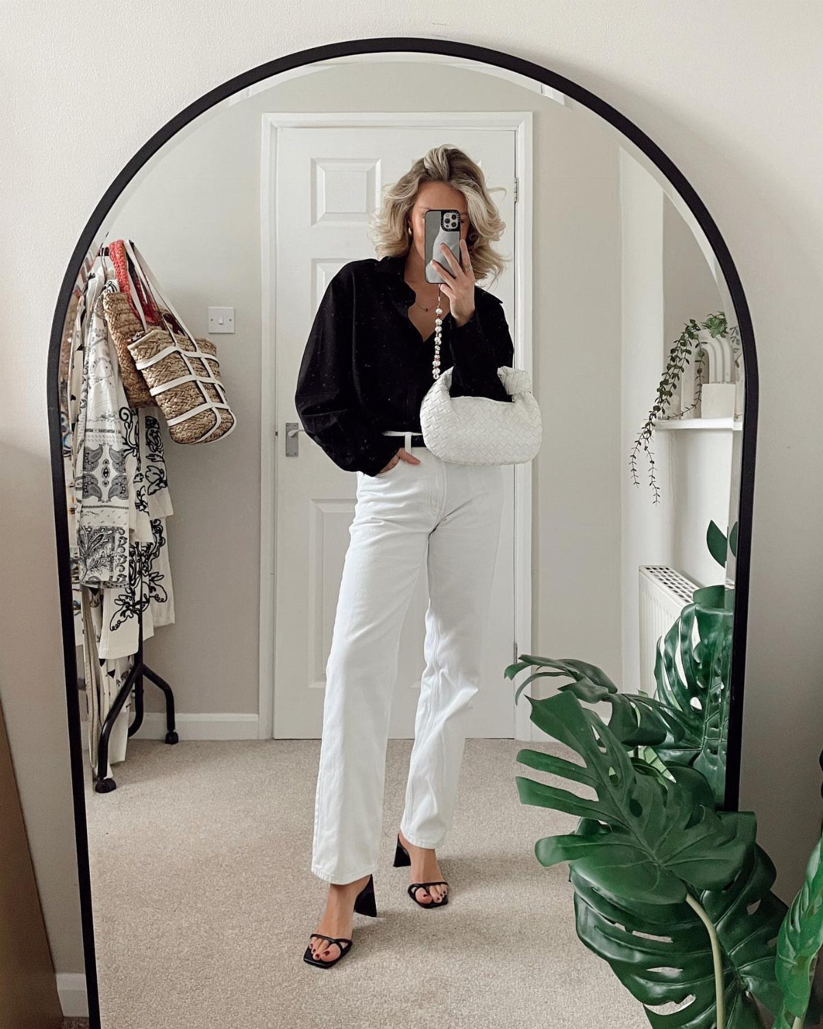 Casual Outfits for Las Vegas: 35 Ideas for Day and Night 4 Woman in black shirt and white wide-leg jeans posing for a mirror selfie.