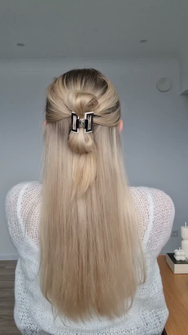 11 Clip Up Hairstyles From French Twists to Half-Up Buns 10 Blonde hair styled in a half-up claw clip bun with loose ends.