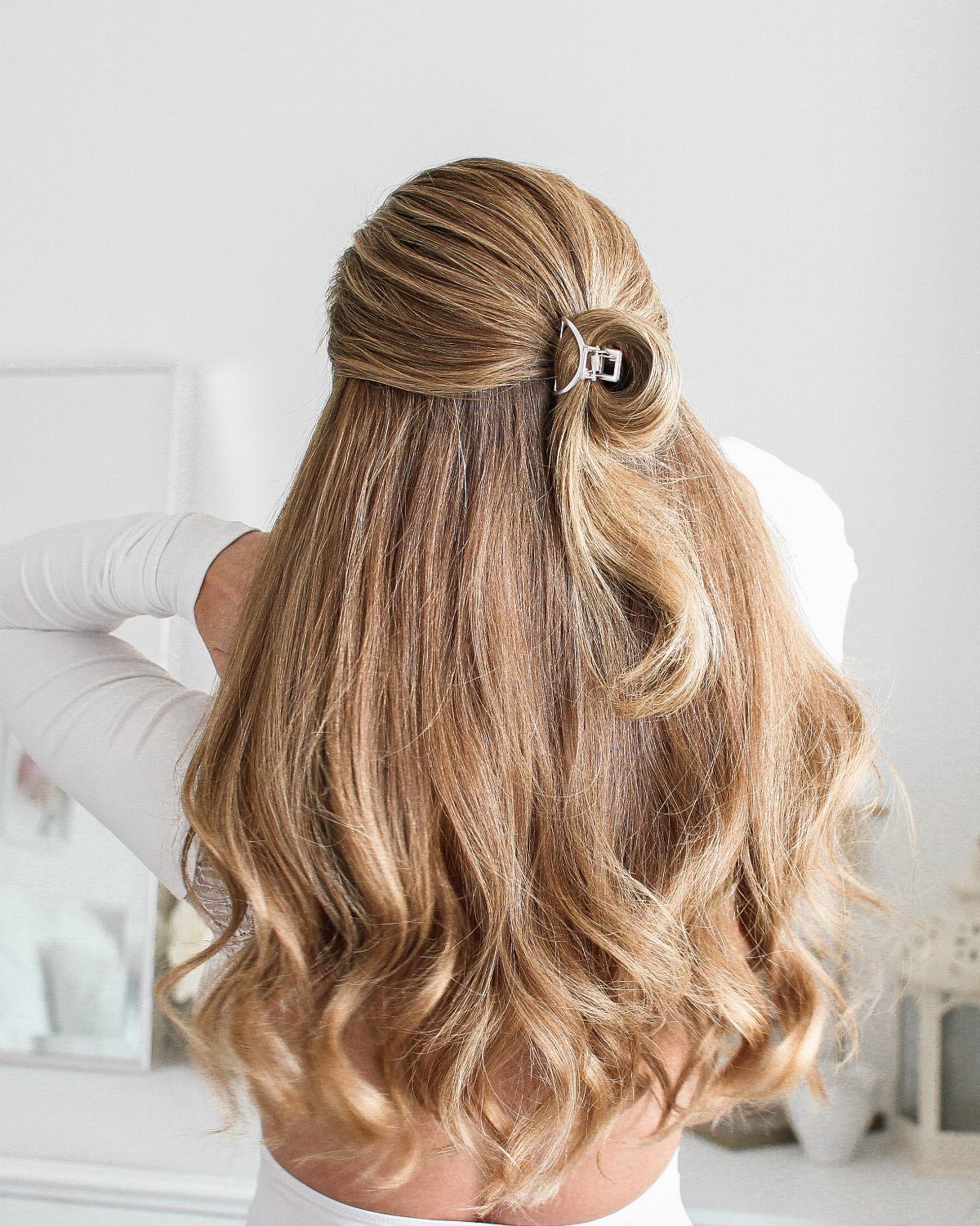 11 Clip Up Hairstyles From French Twists to Half-Up Buns 7 Blonde wavy hair styled in a half-up half-down look with a silver clip.
