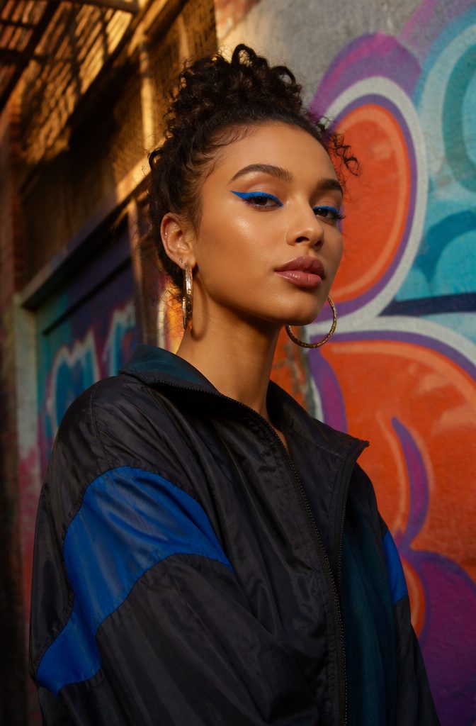 20 Cool Makeup Looks: Creative Ideas to Try in 2026 19 Model with electric blue neon eyeliner in an urban setting.