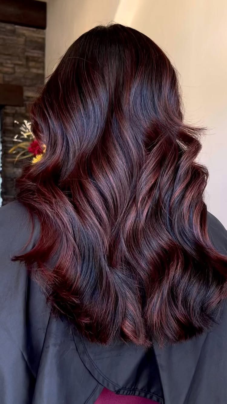 Dark Winter Hair Color: 9 Shades From Black to Burgundy 4 Long wavy hair dyed in a deep burgundy and dark brown glossy shade.