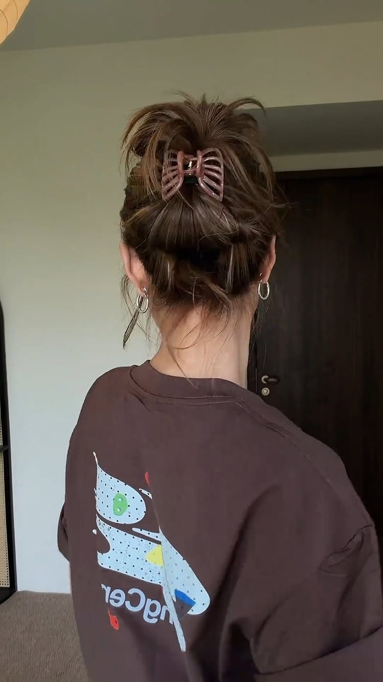 Brown hair styled in a messy bun secured with a brown claw clip