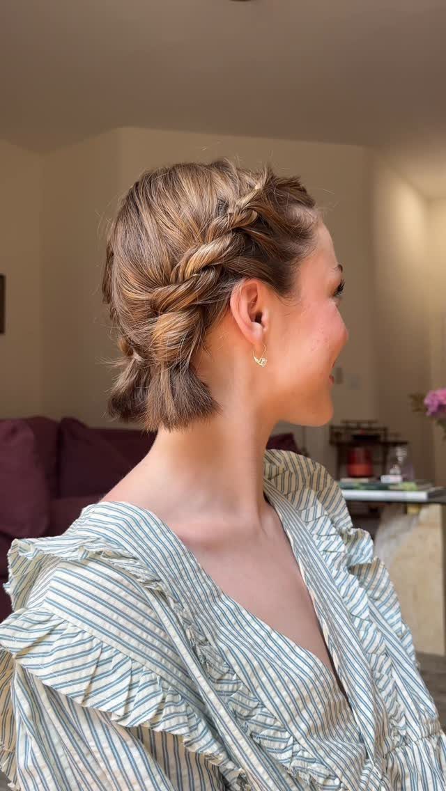 Woman with short brown hair styled in a side braid and twist.