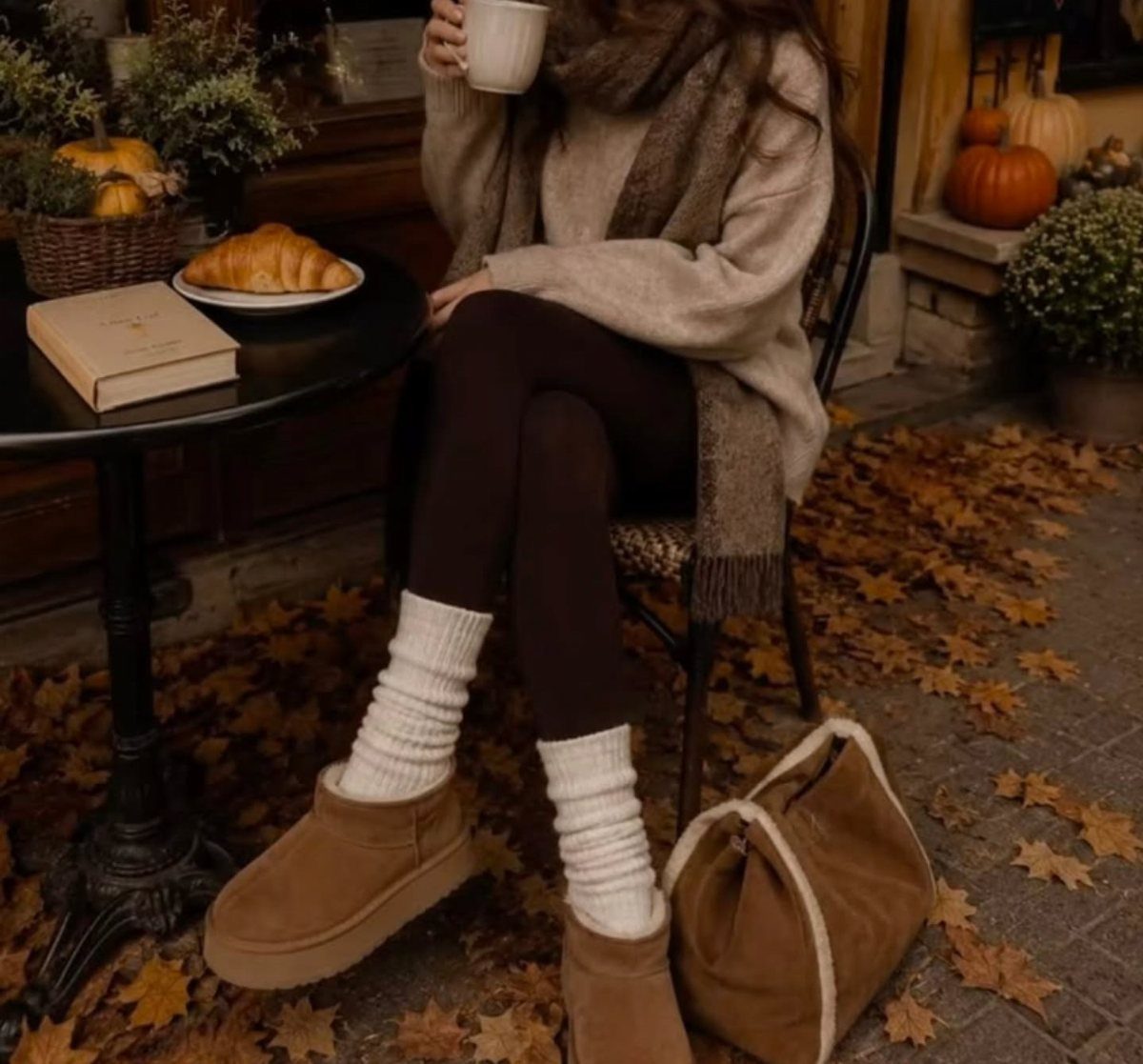 29 Fall Outfits Teens Can Copy, From Grunge to Cowgirl Looks 9 Person in cozy fall clothes holding a coffee mug at a cafe table.