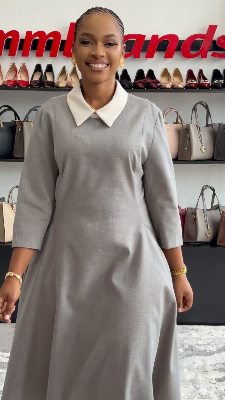 Formal Casual Dresses: 20 Ideas From Shirt Dresses to Velvet 21 Woman wearing a grey formal casual dress with a white collar in a boutique.