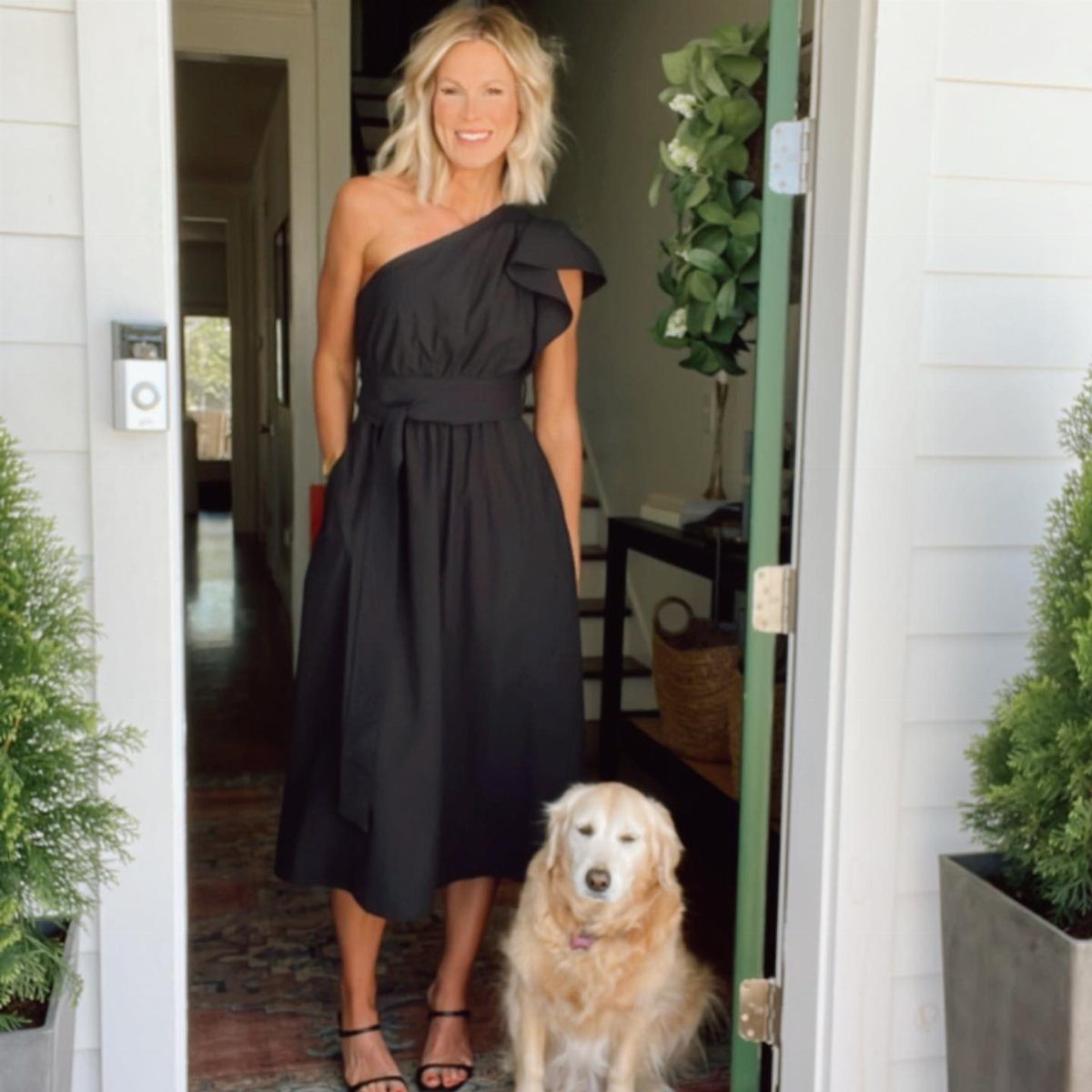 Formal Casual Dresses: 20 Ideas From Shirt Dresses to Velvet 16 Woman in a black one-shoulder midi dress standing in a doorway with a dog.