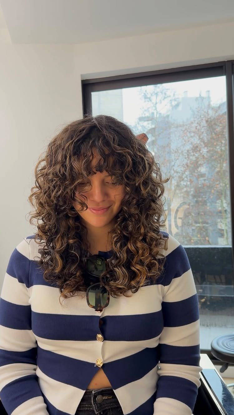 16 Good Hairstyles for Curly Hair, From Pixie to Long Layers 10 Woman with a curly shag haircut featuring voluminous layers and curly bangs.