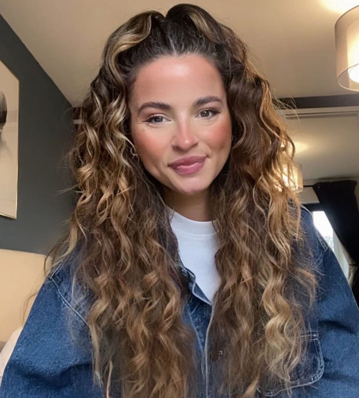 16 Good Hairstyles for Curly Hair, From Pixie to Long Layers 2 Woman with long curly brown hair styled in a half-up half-down ponytail.