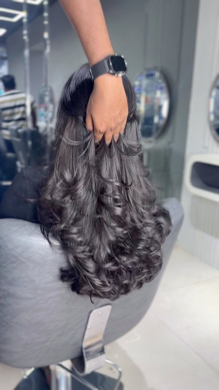 16 Good Hairstyles for Curly Hair, From Pixie to Long Layers 12 Long dark curly hair with layers being lifted by a stylist in a salon.