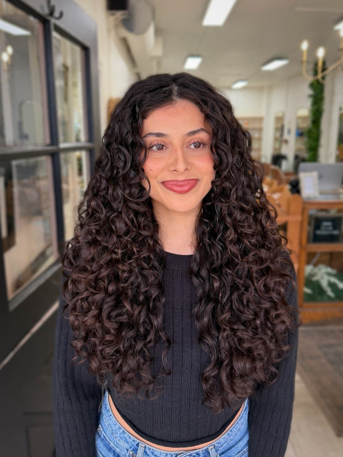 16 Good Hairstyles for Curly Hair, From Pixie to Long Layers 16 Woman with long, voluminous dark brown kinky-curly hair with layers in a salon.