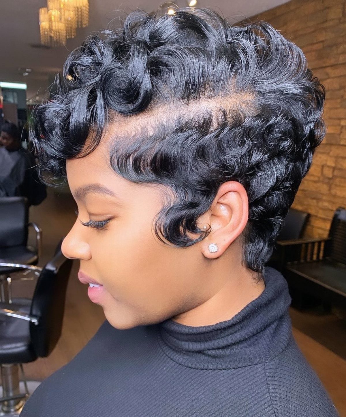 16 Good Hairstyles for Curly Hair, From Pixie to Long Layers 8 Woman with a short, voluminous black curly pixie cut in a salon setting.