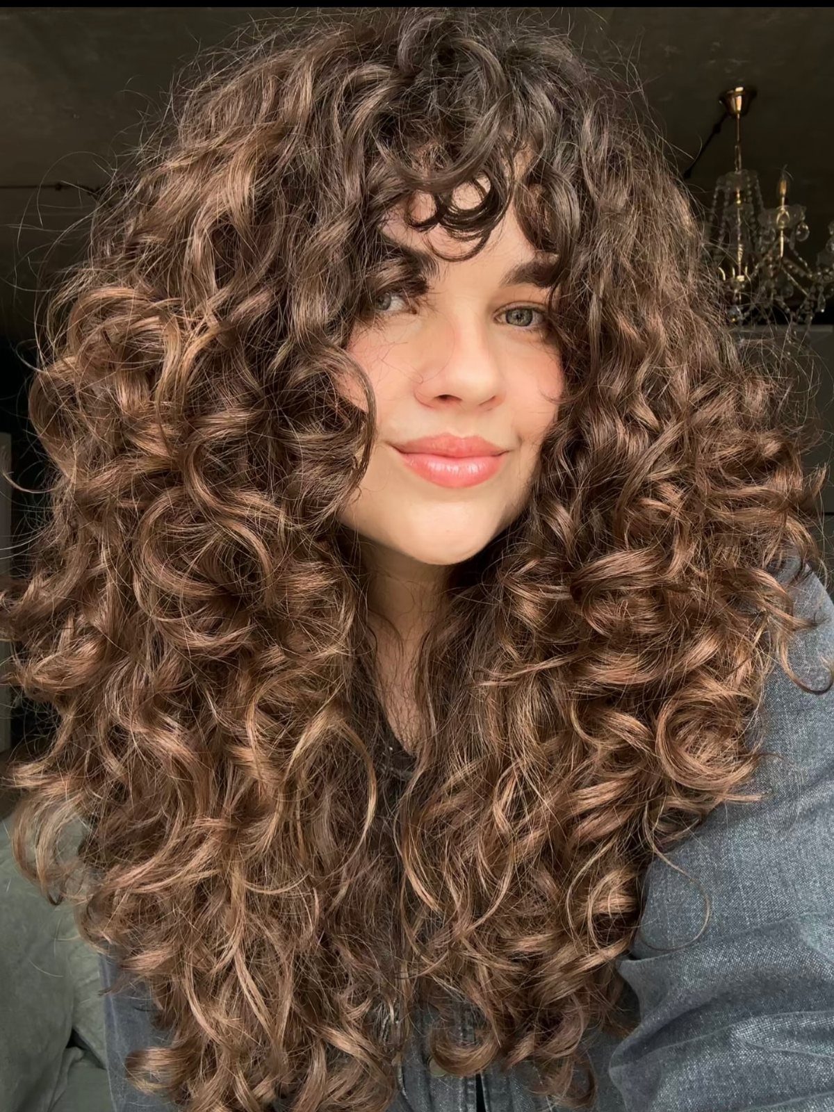 16 Good Hairstyles for Curly Hair, From Pixie to Long Layers 15 Woman with long brown curly hair featuring a soft curly fringe and layers.