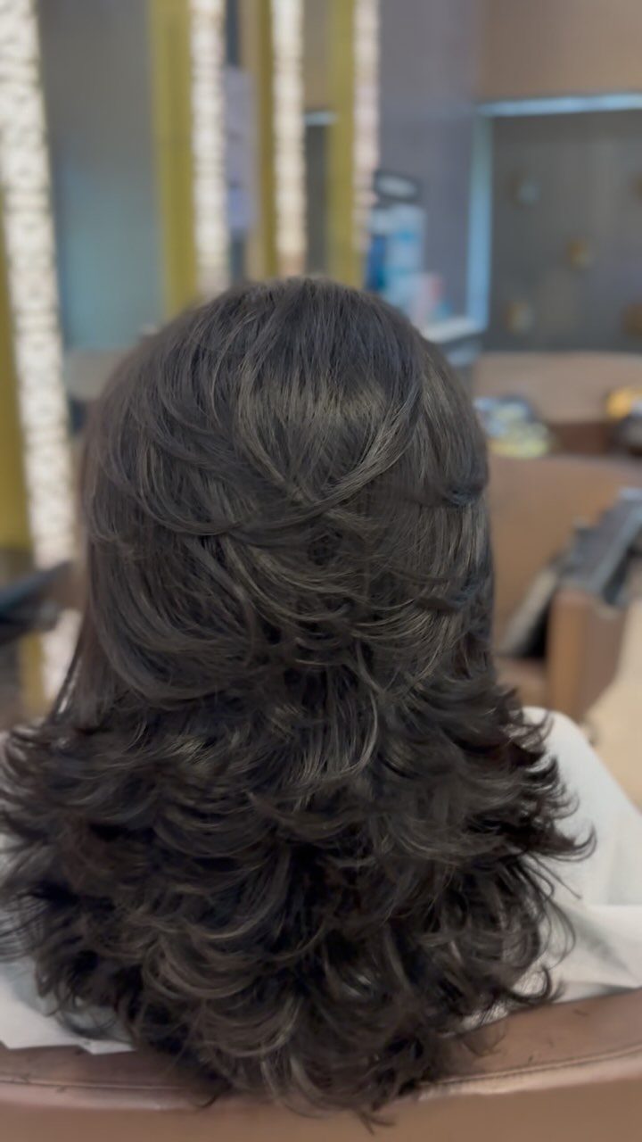 Dark brown semi-curly hair styled in a layered cut seen from behind.