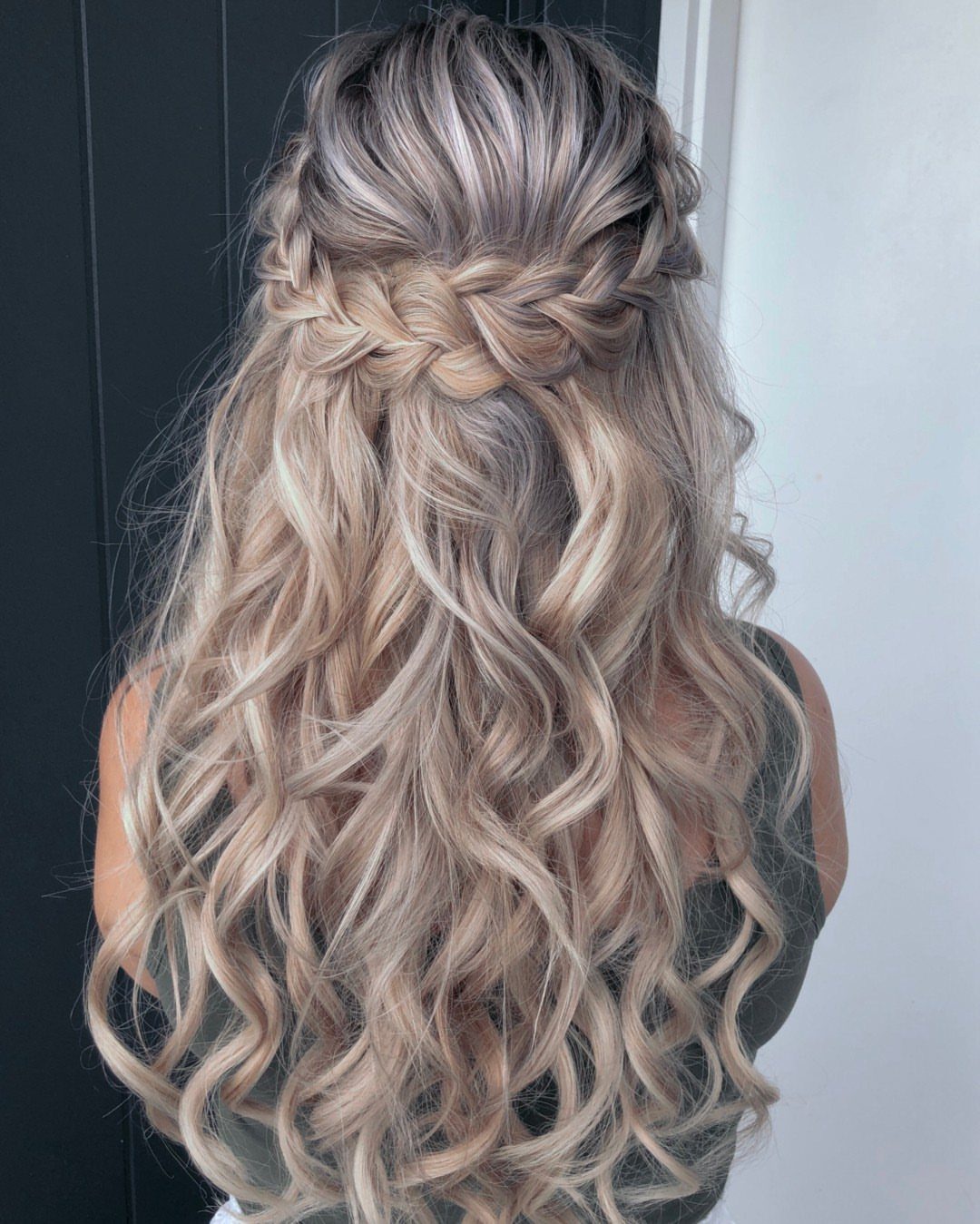 Long blonde curly hair with a horizontal braid wrapped across the back.