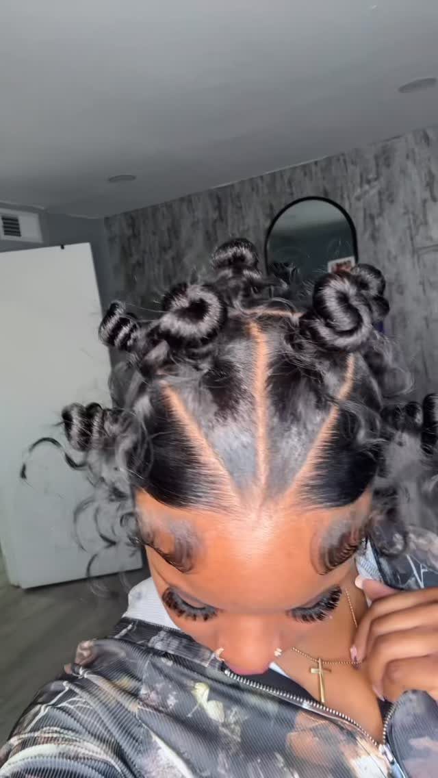 Person with dark hair styled in multiple small, defined bantu knot curls.