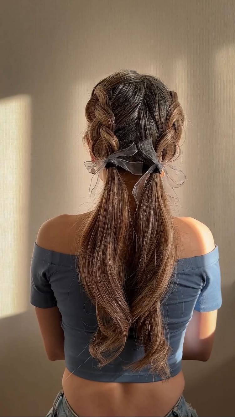 Brown hair styled in half-braided pigtails tied with a sheer grey ribbon bow.