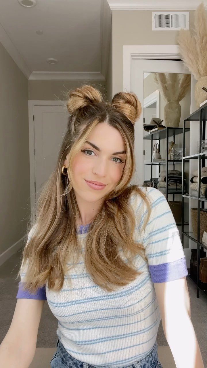 Woman with blonde hair styled in half-up space buns and loose waves.