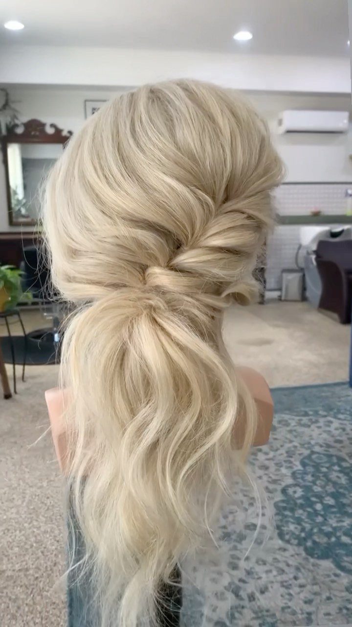 Blonde hair styled in a loose, low side ponytail on a mannequin head.