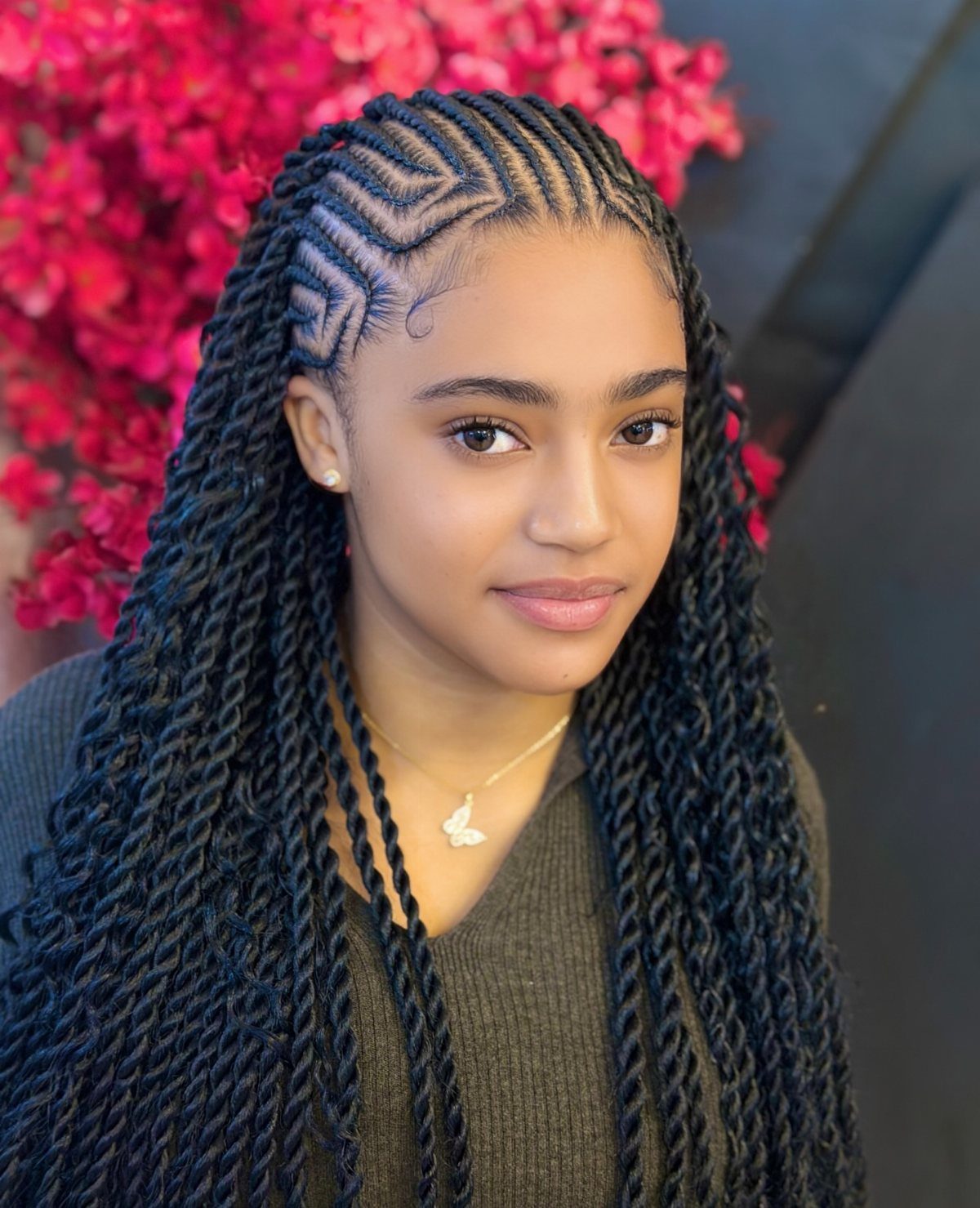 Young woman with geometric patterned cornrows and long dark hair twists.