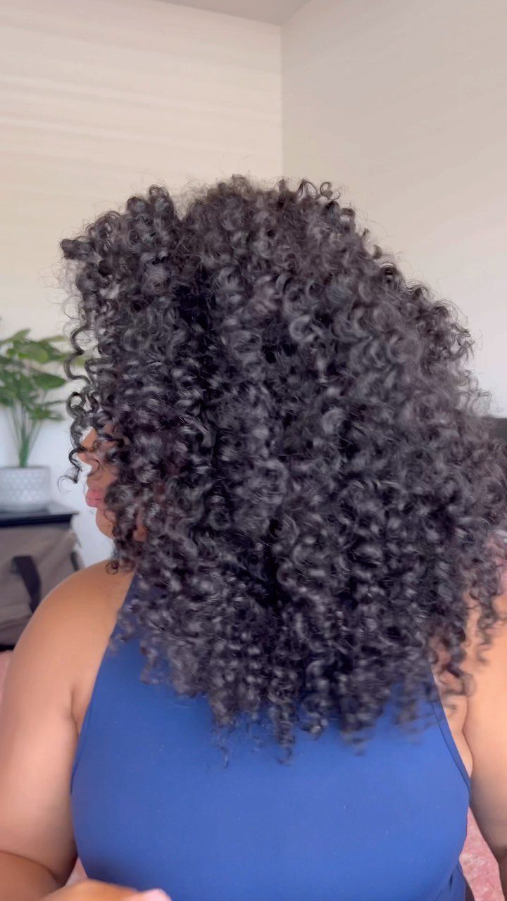 Voluminous dark curly hair in a twist-out style on a person wearing blue.