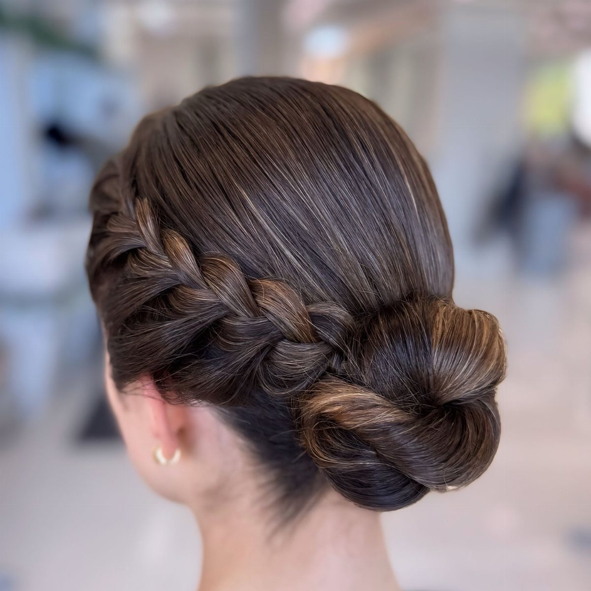 12 Hairstyles to Hide Bangs, From Quick Sweeps to Sleek Buns 10 Brown hair styled in a side braid and low polished bun updo.