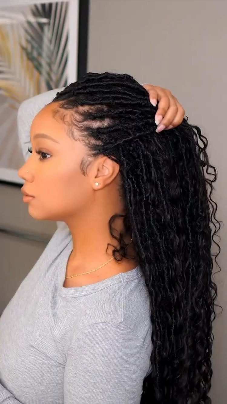 Woman with long curly black crochet braids and cornrows in a side profile