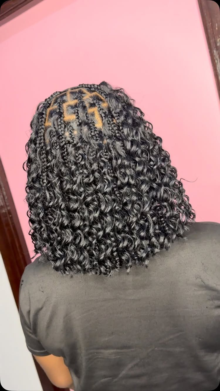 Black hair styled in a curly bob with braided roots from behind.
