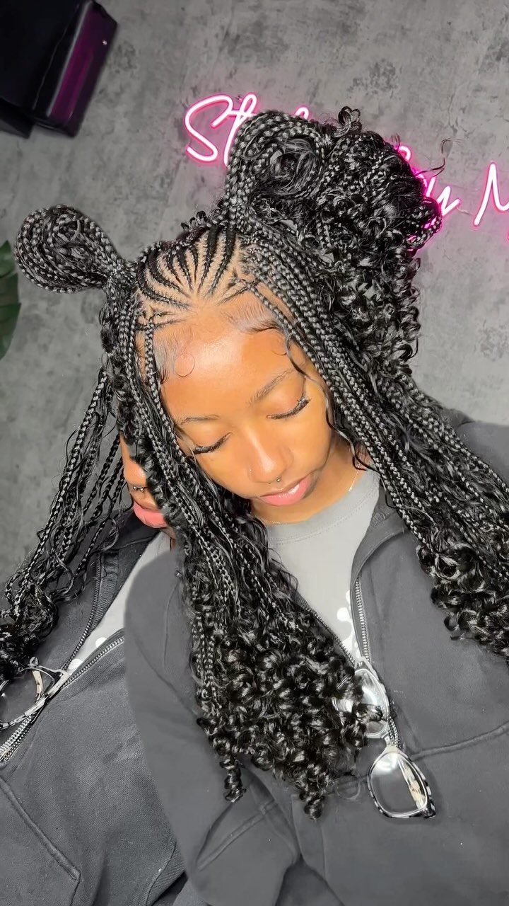 Woman with black goddess braids featuring curly ends and top buns.