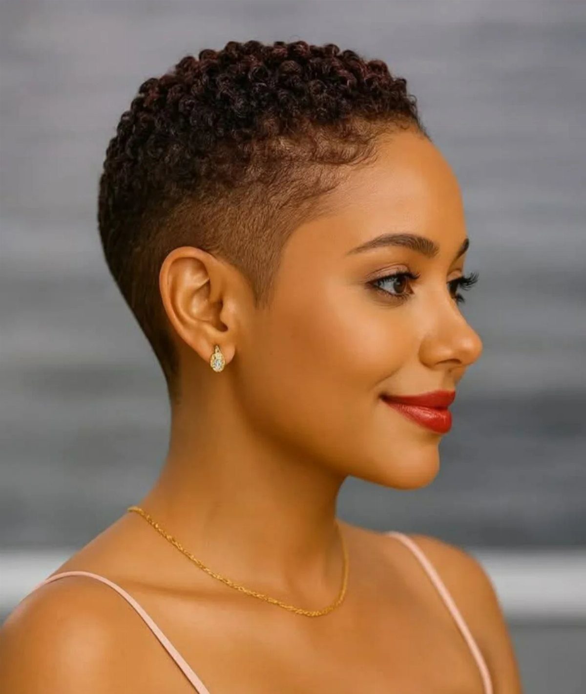 Woman with a high top fade haircut, textured black hair and faded sides.