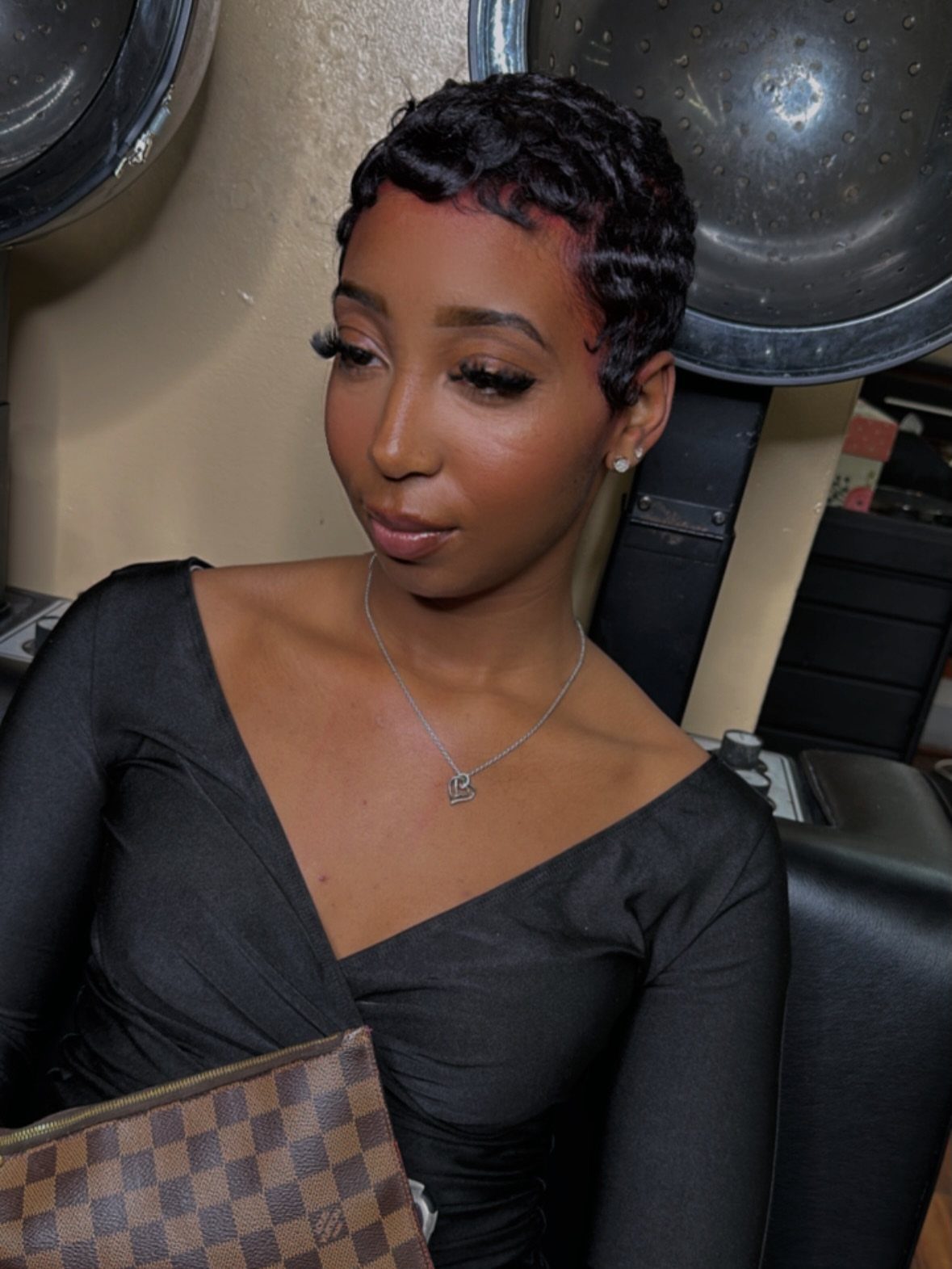 Woman with a short tapered cut and curly black hair in a salon.