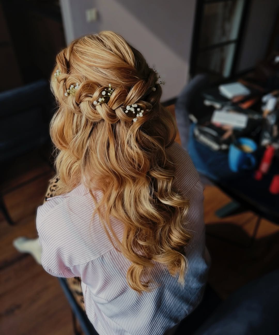 7 Half Braid Half Curly Hairstyles for Braids Mixed With Curls 3 Strawberry blonde curly hair with a horizontal crown braid decorated with white flowers.
