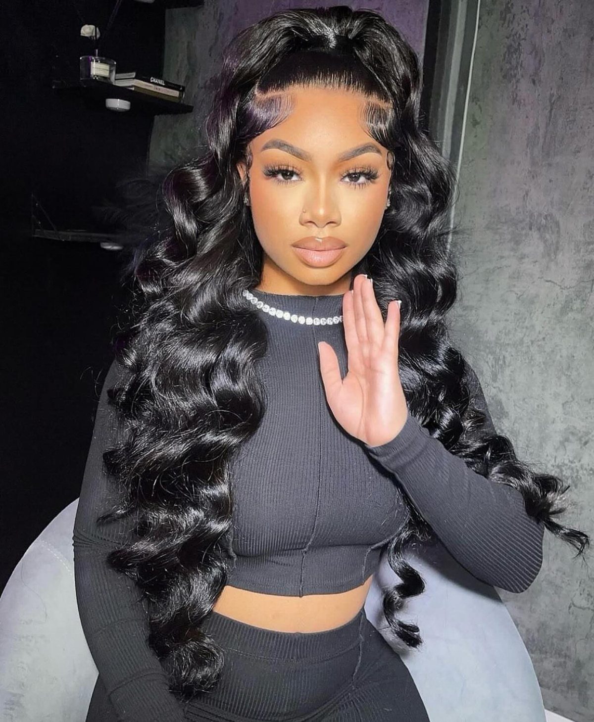 7 Half Braid Half Curly Hairstyles for Braids Mixed With Curls 2 Woman with long black curly hair in a half-up half-down ponytail hairstyle.