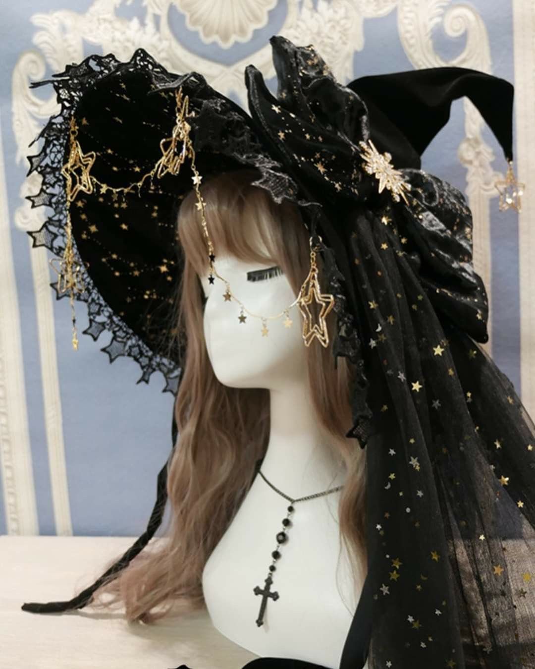 Black pointed witch hat with gold star veil on a mannequin head